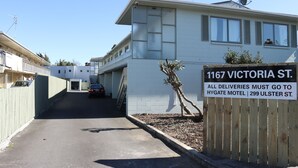 Un edificio con un cartello che indica che le consegne devono essere dirette al motel Hygate in via Ulster 299.