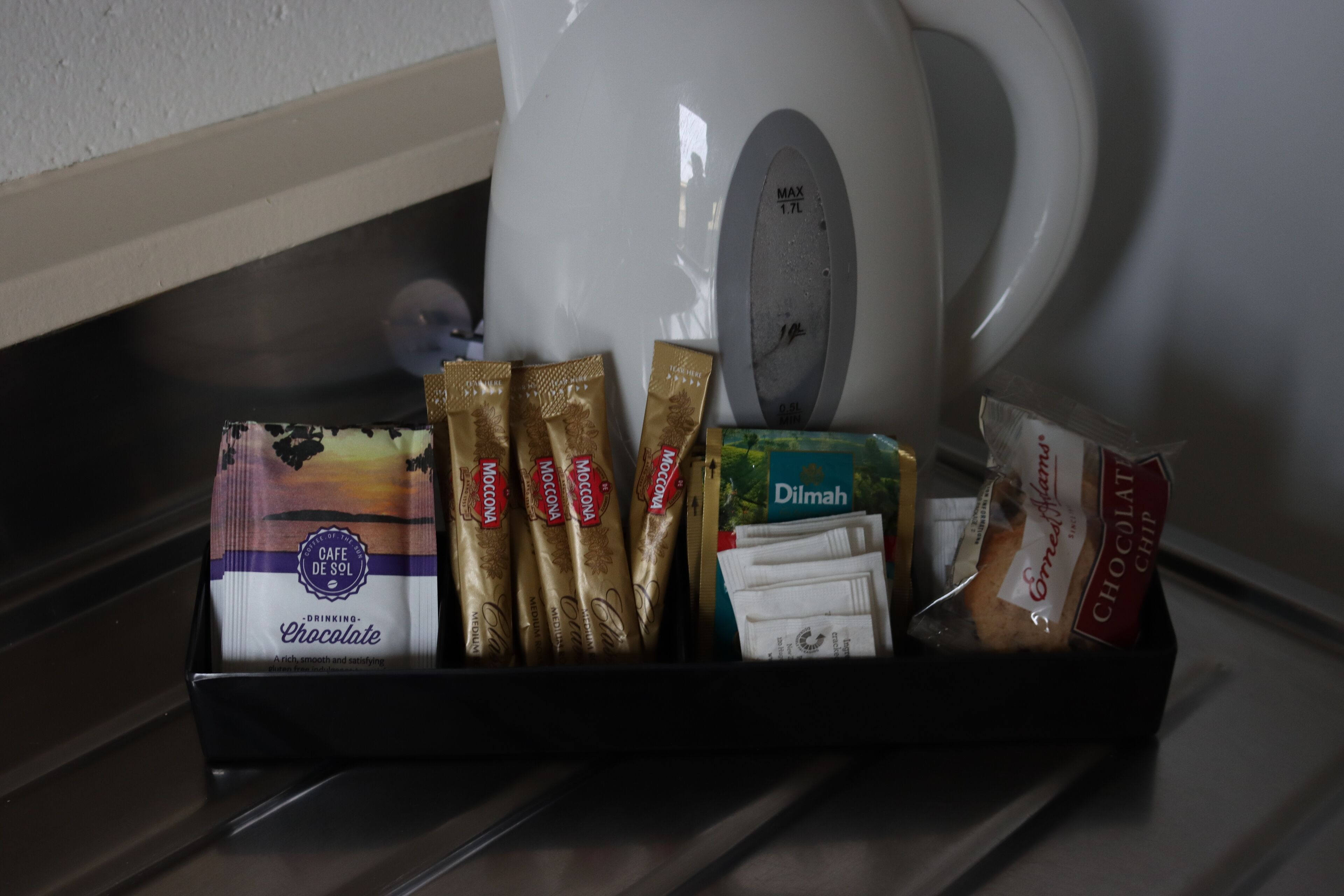 A tray with various chocolate bars and a coffee maker.