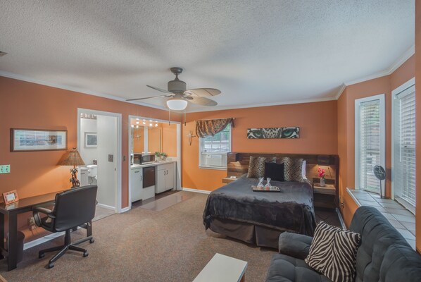 A bedroom with a bed, a desk, a chair, a sofa, and a ceiling fan. -  Private Studio Entry (Ponte Vedra Beach)