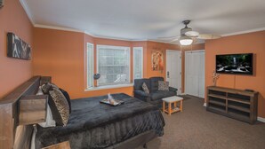 A bedroom with a bed, a chair, a TV, and a ceiling fan. -  Private Studio Entry (Ponte Vedra Beach)