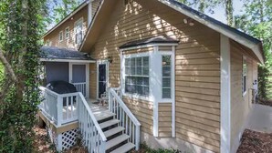 A two-story house with a front porch, a small deck, and a staircase leading to the entrance. -  Private Studio Entry (Ponte Vedra Beach)