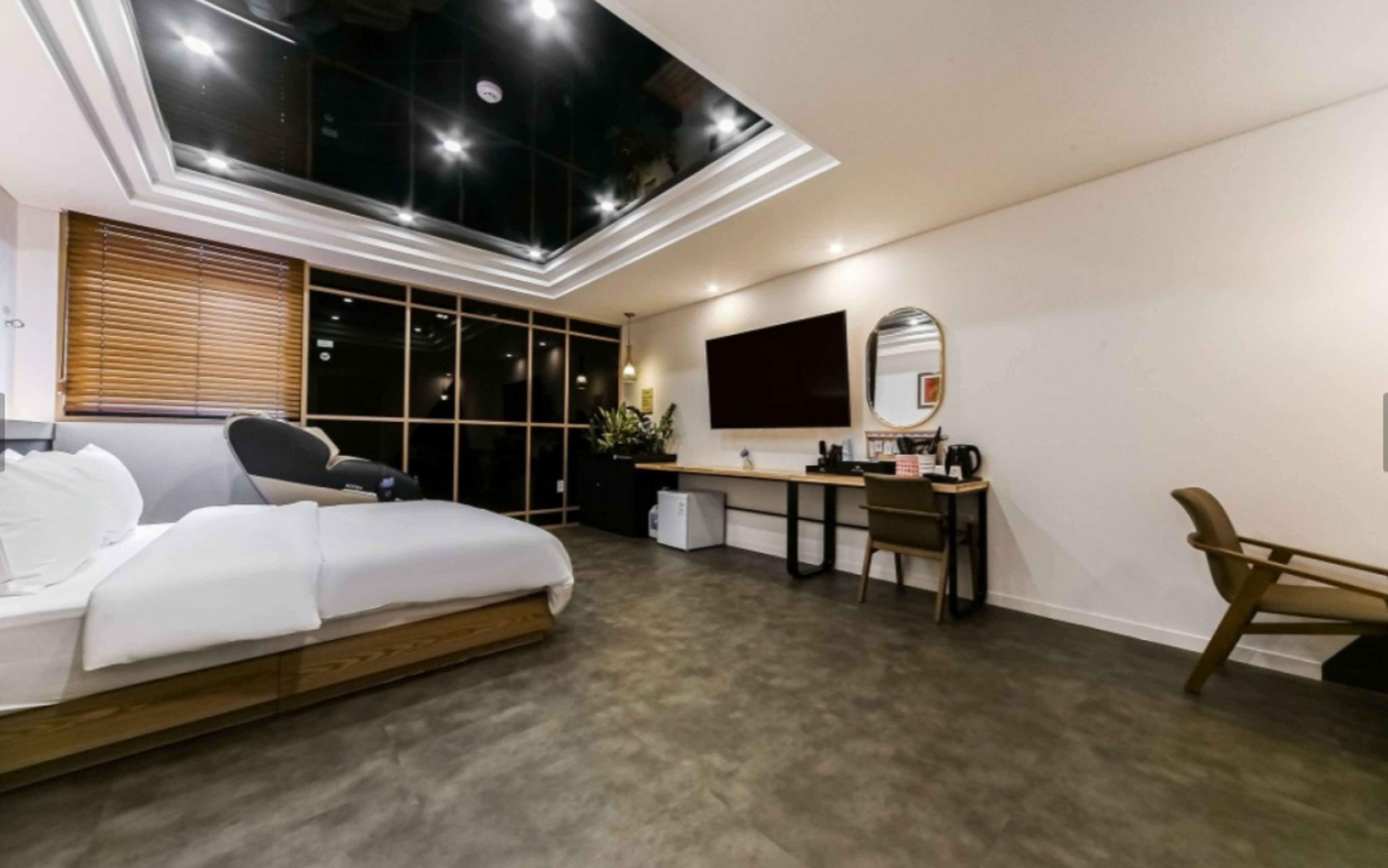 Ein modernes Schlafzimmer mit Oberlicht, Bett, Schreibtisch und Stuhl.