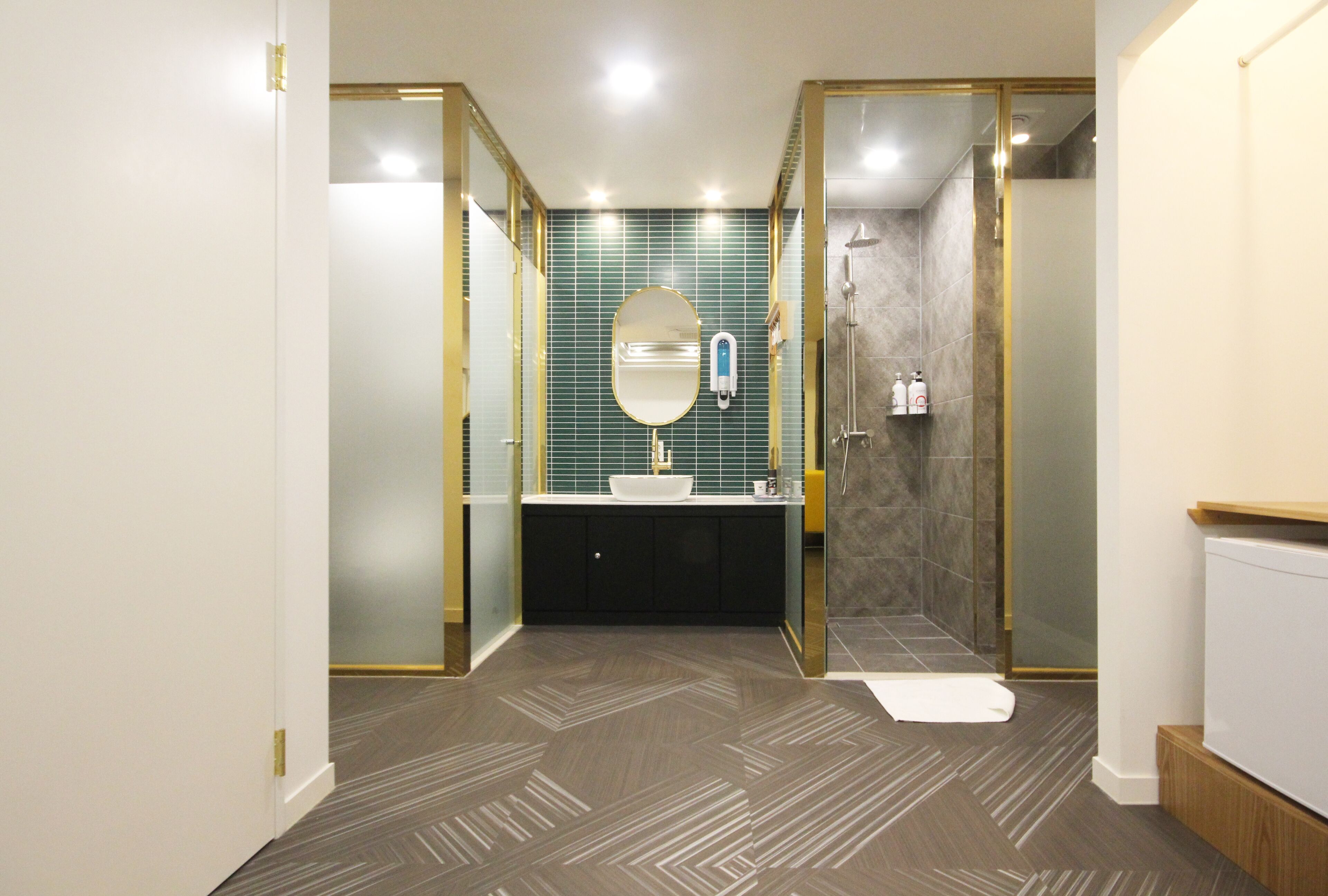 A modern bathroom with a freestanding mirror, a white sink, and a shower enclosure.