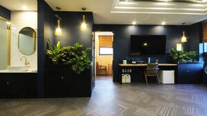 A modern bathroom with a sink, mirror, and potted plants. - Amare Hotel (Daegu)