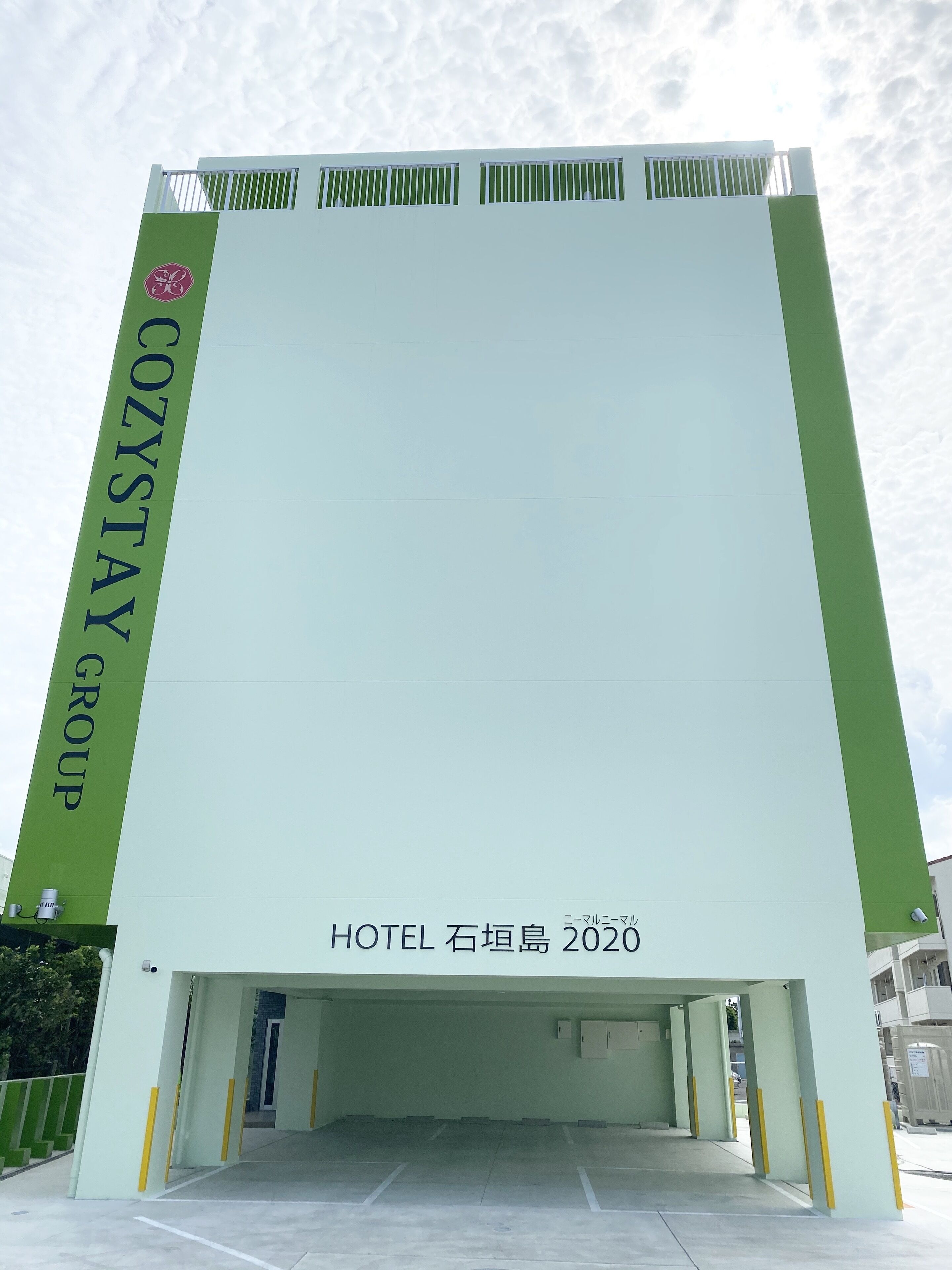 A hotel entrance with a large sign reading "COZYSTAY GROUP HOTEL 石垣島 2020".