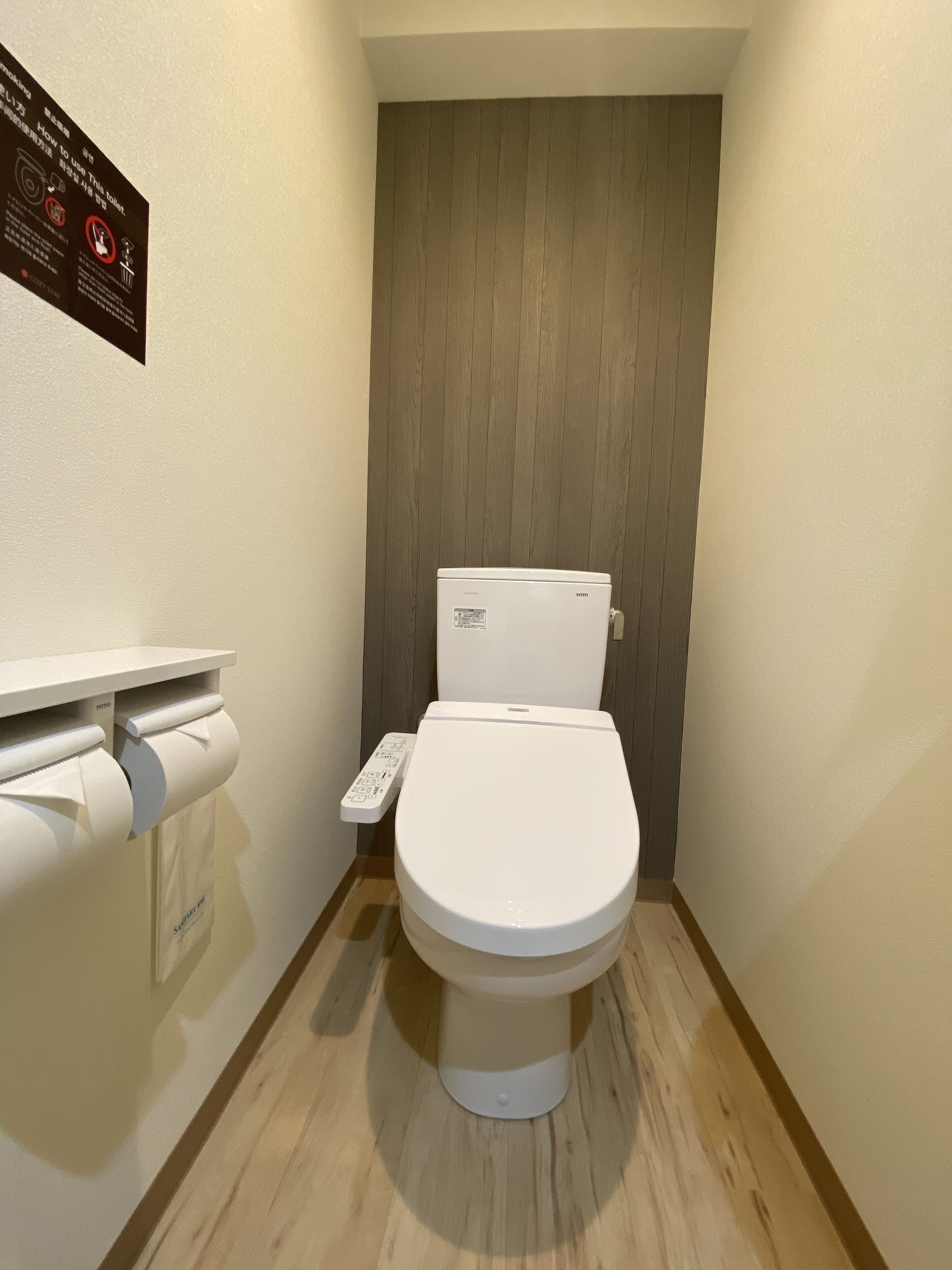 Un inodoro moderno con panel de control y dispensador de papel higiénico.