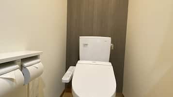 Un inodoro moderno con panel de control y dispensador de papel higiénico.