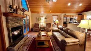 Una sala de estar acogedora con chimenea, un sofá de cuero y un comedor con mesa y sillas.