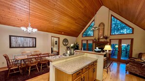 Una cocina amplia con armarios de madera, una isla grande y un comedor con sillas de madera.