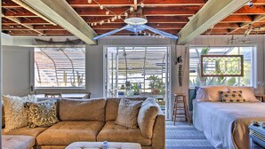 A cozy room with a sofa, a bed, and a window with a view of the outdoors. - Fire Pit, Views & Beach Access: Waterfront Escape! (University Place)