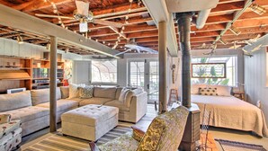A spacious living area with a high ceiling, exposed wooden beams, and a cozy fireplace. - Fire Pit, Views & Beach Access: Waterfront Escape! (University Place)