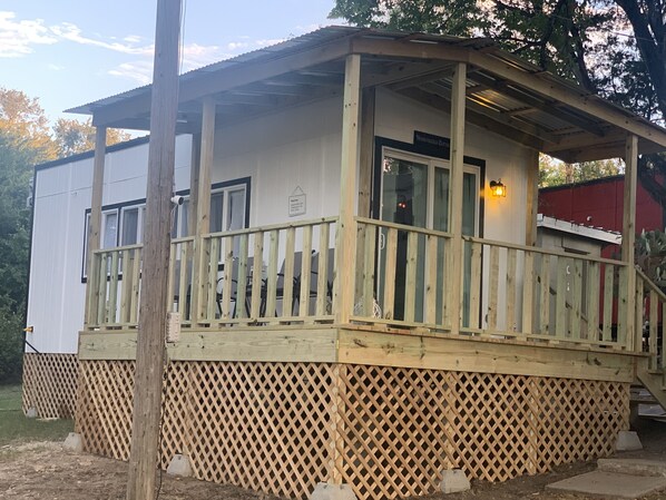 A wooden deck with a railing, a covered porch, and a sign indicating a restaurant.