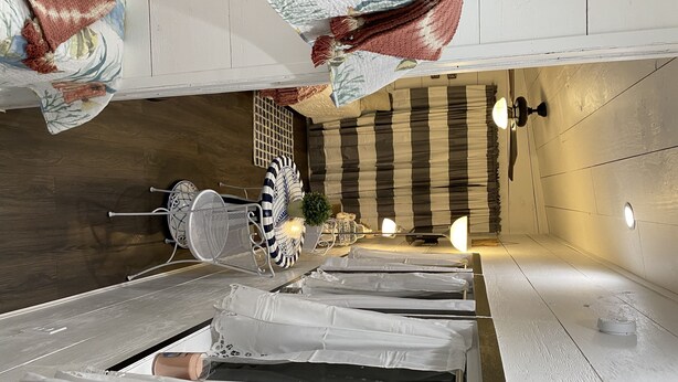 Een netjes ingerichte kamer met een bed, een stoel en een tafel.