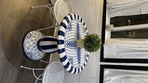 Een eethoek met een ronde tafel, stoelen en een potplant.