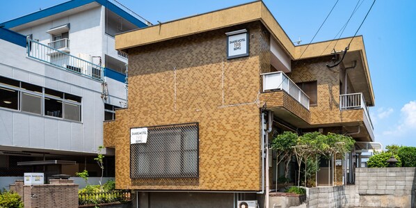A multi-story building with a sign indicating it is a share hotel. - SHARE HOTEL 198 Beppu (Beppu)