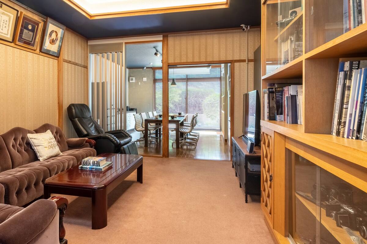 Una sala de estar con un sofá marrón, una mesa de centro y una estantería.