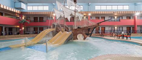 An indoor water park with a pirate ship play area, slides, and a pool.