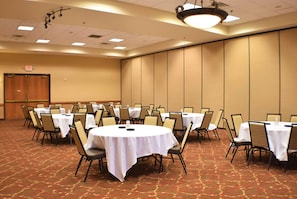 A conference room with round tables, chairs, and a carpeted floor. - Ramada by Wyndham Sioux Falls Arpt & Suites (Sioux Falls)