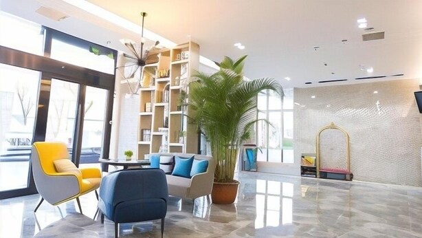 Eine moderne Lobby mit Sitzgelegenheiten, einer hohen Pflanze und einem Empfangstisch.