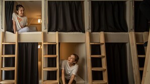 A bunk bed room with wooden ladders and black curtains. - The Terrace Hostel Shinbashi (Tokyo)