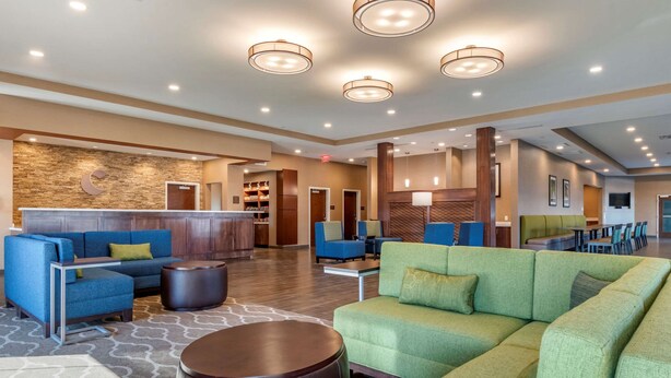 A spacious lobby with a reception desk, seating area with sofas and chairs, and a wooden wall with a crescent moon design. - Comfort Suites Camp Hill-Harrisburg West (Camp Hill)