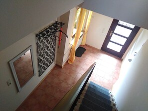 A staircase leading to a room with a window, a door, and a curtain.