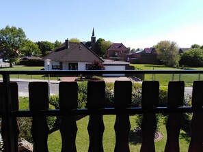 Ein Wohngebiet mit einem weißen Haus, einer schwarzen Tür und einem roten Blumenbeet im Vorgarten.