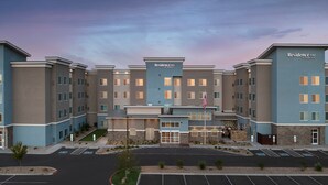 A multi-story hotel with a central entrance, parking lot, and a flag. - Residence Inn by Marriott Lubbock-University Area (Lubbock)