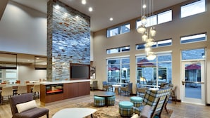 A spacious lobby with a stone accent wall, a bar area, and comfortable seating. - Residence Inn by Marriott Lubbock-University Area (Lubbock)