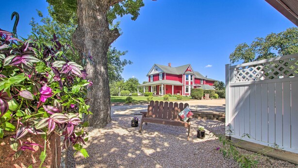 A red house with a porch, a wooden bench, and a lattice fence. - Cozy Ironton Cabin w/ Shared Pool & Private Patio! (Ironton)