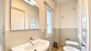 Une salle de bain équipée d’un lavabo, de toilettes et d’un bidet.