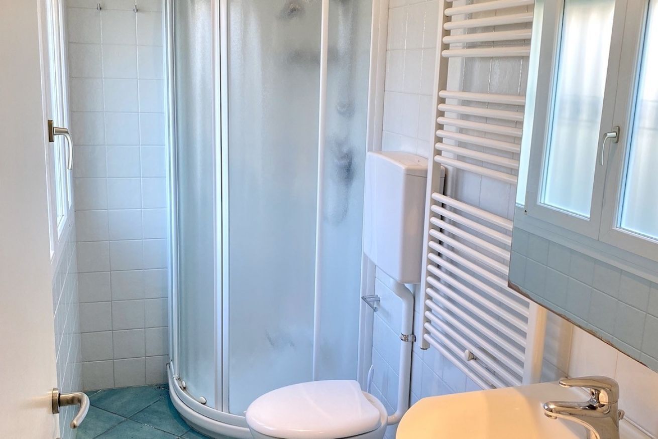 A bathroom with a shower, toilet, and sink.