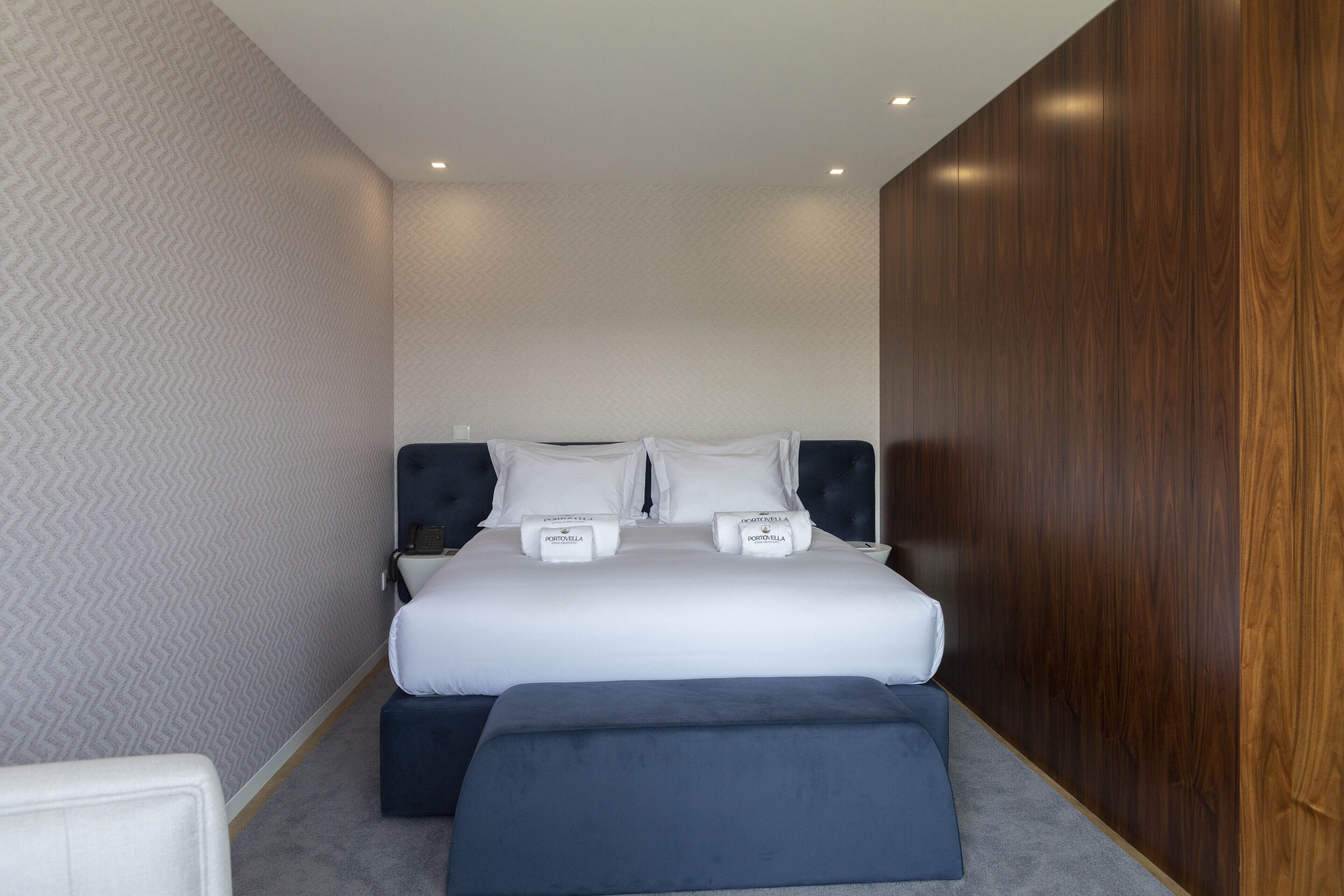 Een moderne hotelkamer met een groot bed, twee nachtkastjes en een houten accentmuur.