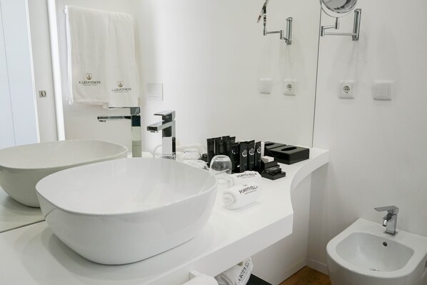 A modern bathroom with two large white sinks, a bidet, and a mirror. - Portovella (Baiao)