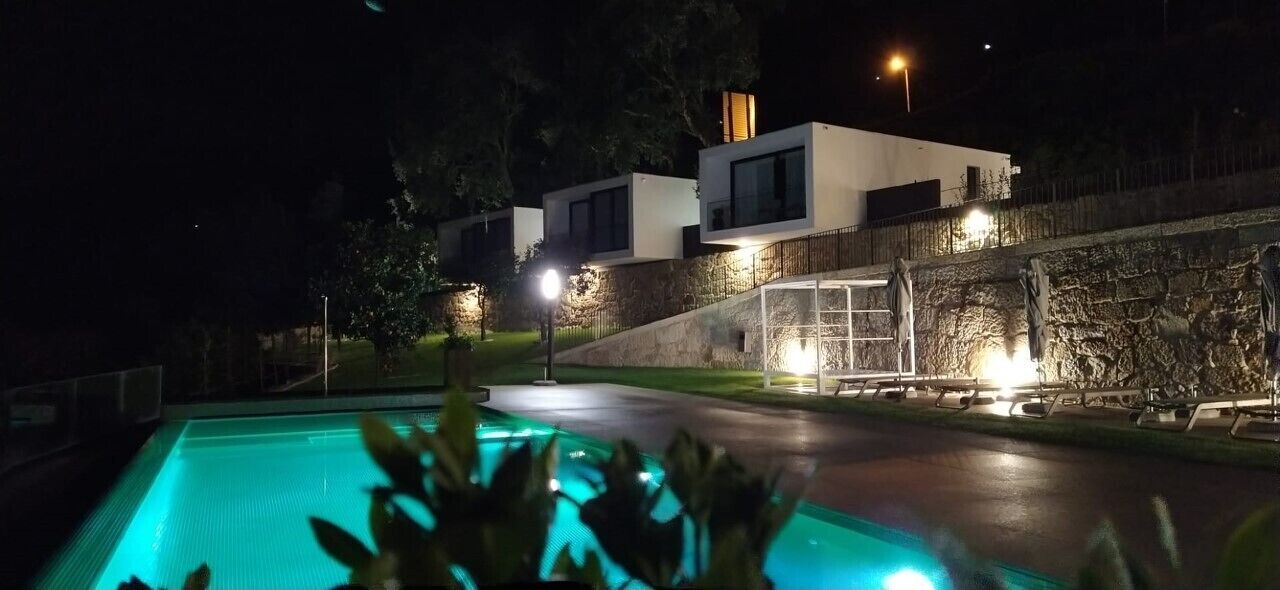 A modern building with a swimming pool at night.