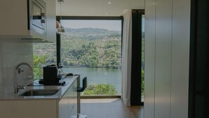A modern kitchen with a view of a lake and hills. - Portovella (Baiao)
