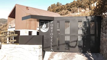 A modern building with a wooden upper section and a black lower section, featuring a logo and the name 'PORTOVELLA'.