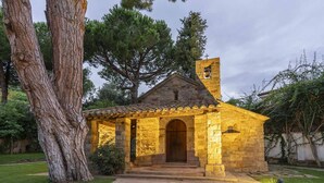 Une chapelle en pierre dotée d’un clocher, d’une porte en bois et d’un toit recouvert de tuiles.