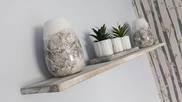 A shelf with three decorative vases and a small plant.