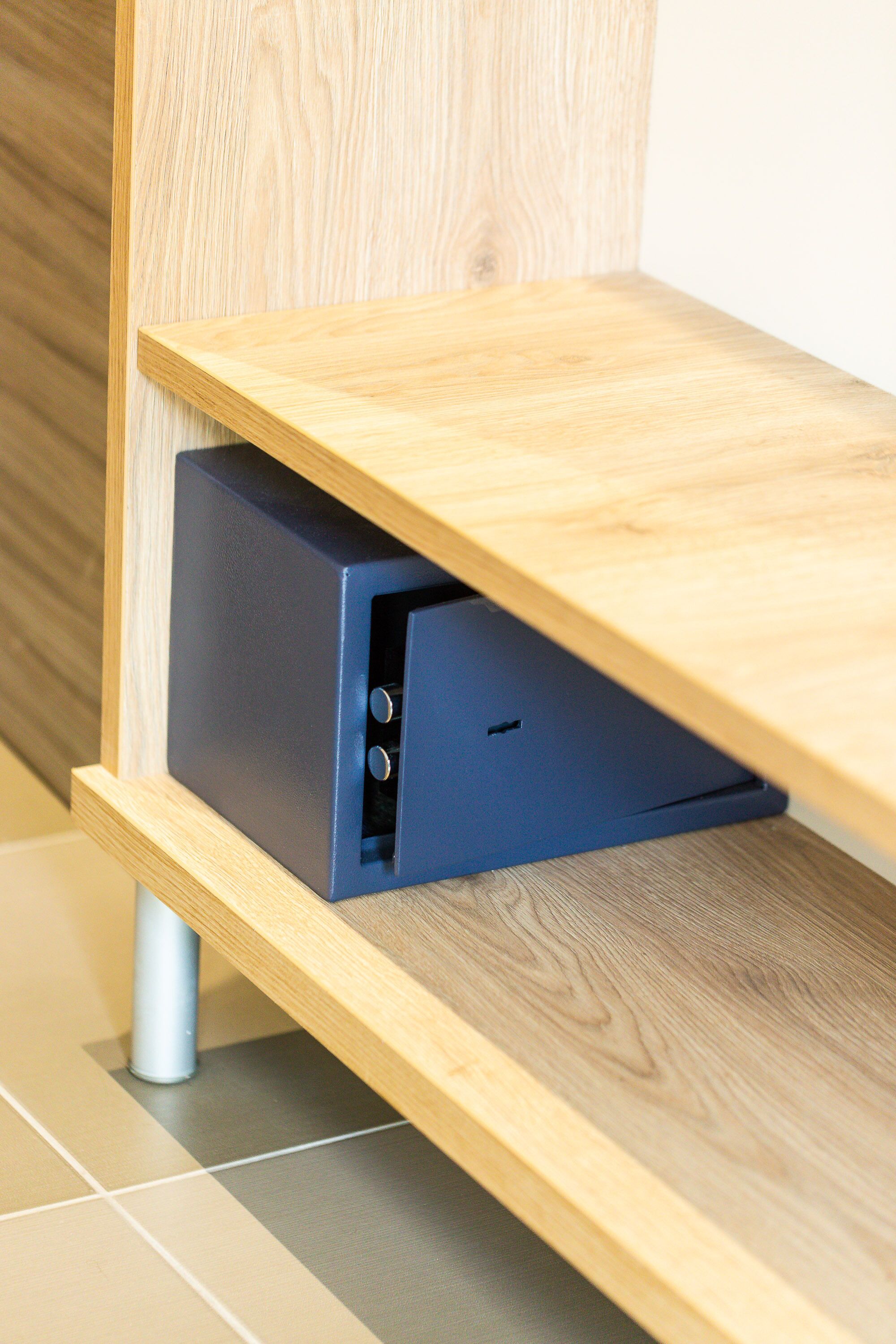 Une étagère en bois, avec un appareil électronique de couleur sombre placé en dessous.