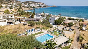 A coastal resort with a swimming pool, beach access, and hillside views.