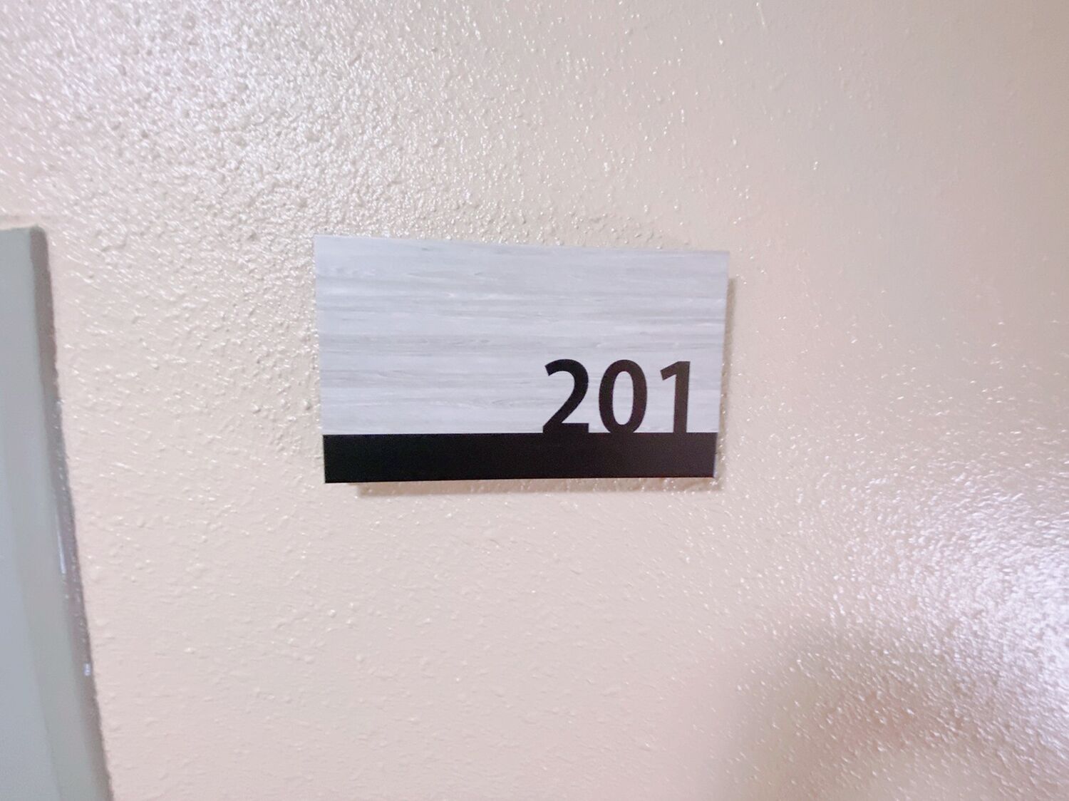 A wall-mounted sign with the number 201.