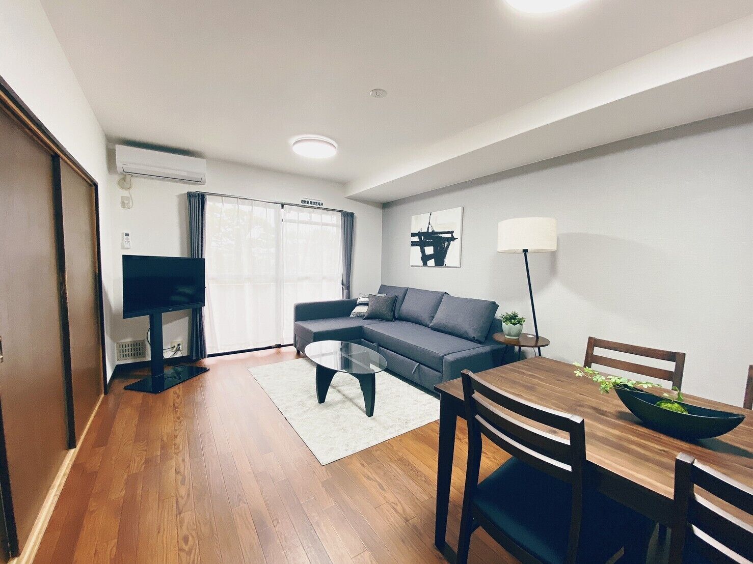 Een moderne woonkamer met een bank, salontafel en eettafel.