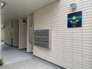 A hallway with lockers and a sign indicating the location as "Plein Soleil." - OUCHI HOTEL Miyajimaguchi (Hatsukaichi)