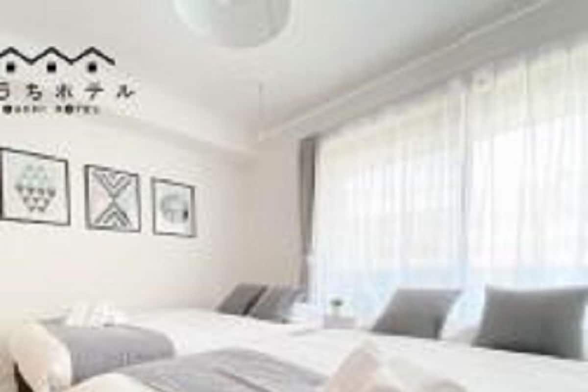 Une chambre d’hôtel avec un lit, une table de chevet et une fenêtre avec des rideaux.