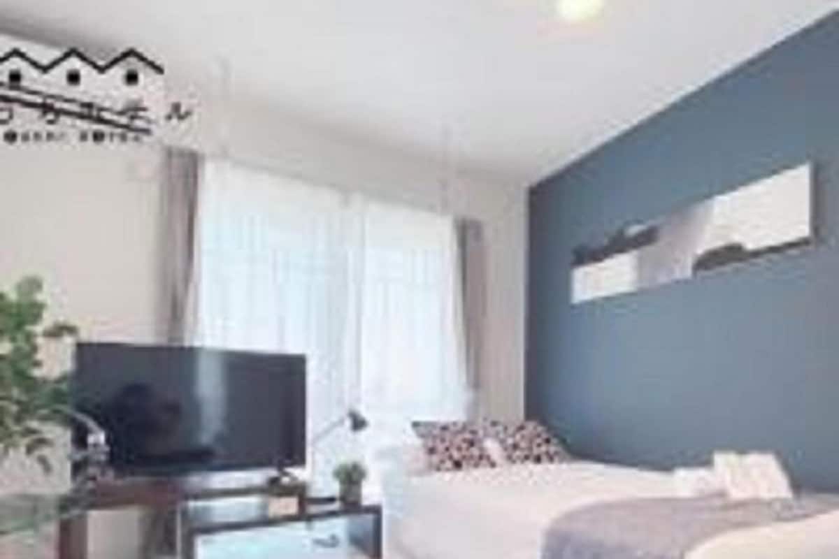 Ein modernes Schlafzimmer mit Bett, Fernseher und einer Sitzecke.