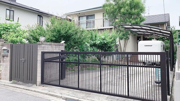 A gated residential area with a white RV parked in front of a house. - Itsukaichi First Villa Hiroshima (Hiroshima)