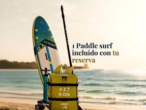 A surfboard with the brand 'AZTRON' and a yellow life jacket with the same brand.