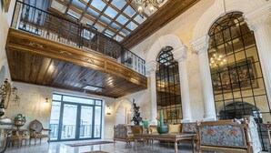 A grand interior with a high ceiling, wooden beams, and a balcony. - Sobek Stone House Cappadocia (Nevsehir)