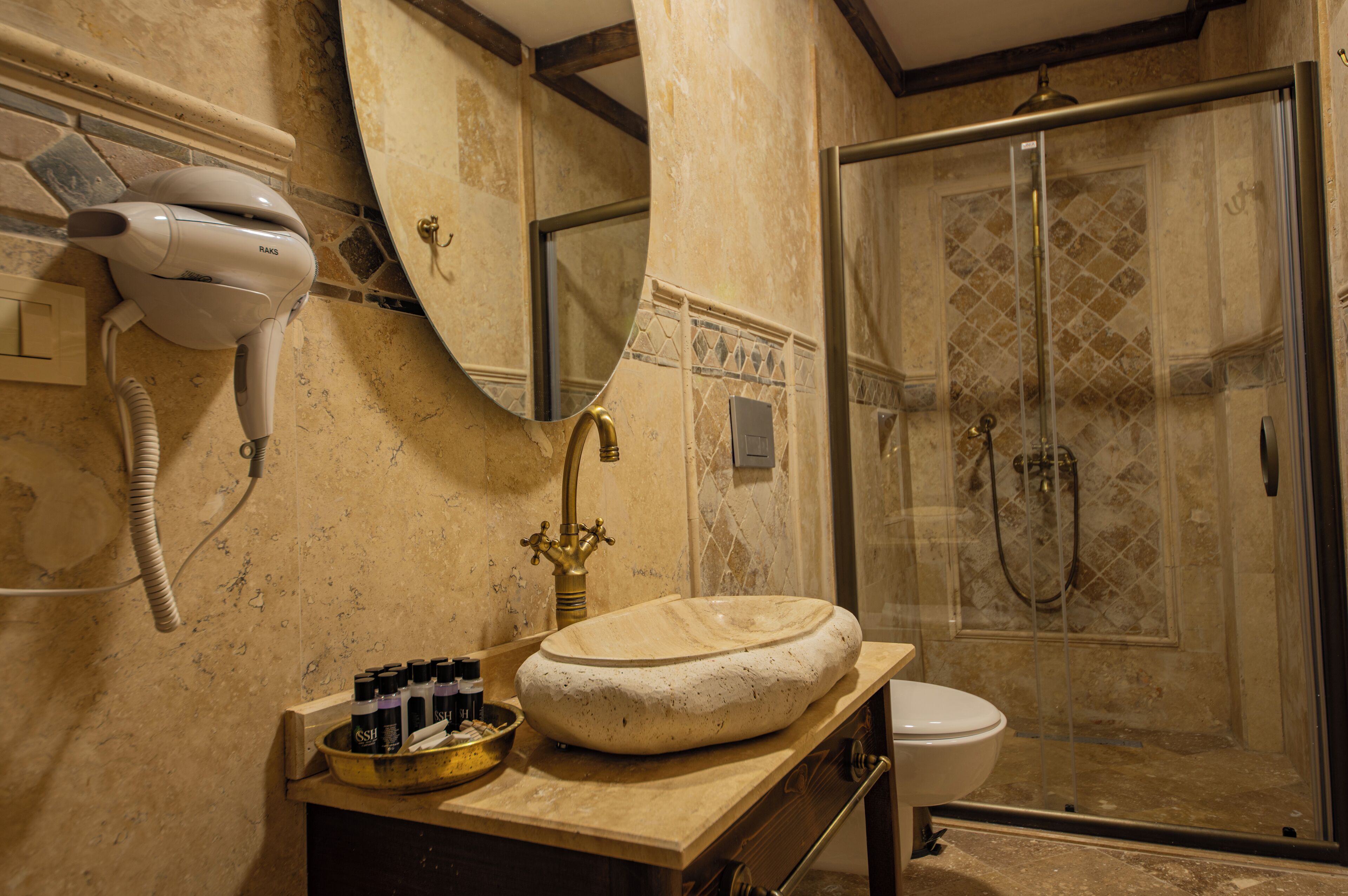 Un baño con un espejo grande, un secador de pelo, un lavabo y una ducha.